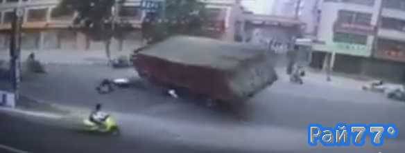 Женщина, сидящая за спиной у мотоциклиста, чудом не попала под гружёную углём фуру в Китае (Видео)