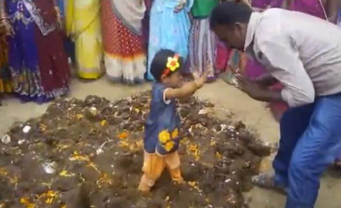 Шокирующий ритуал в Индии: детей окунают в коровий навоз ради их здоровья и благосостояния. (Видео)