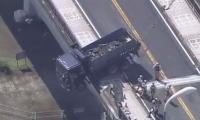 Водитель оказался между небом и землёй в кабине грузовика, проломившего заграждение моста в Японии (Видео)