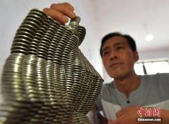 Китайский фермер создаёт скульптурные сооружения из монет. 2