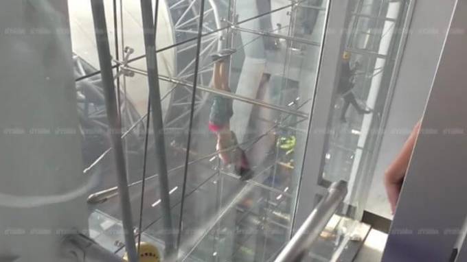 Девушка, угрожая самоубийством, два часа провисела на металлоконструкции в аэропорте Бангкока. (Видео)