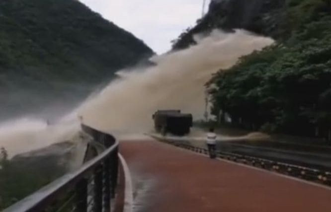 Водитель грузовика проехал под бурным потоком в горах Китая (Видео)