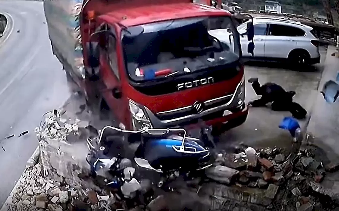 Неуправляемый грузовик чудом не раздавил мотоциклиста и попал на видео в Китае