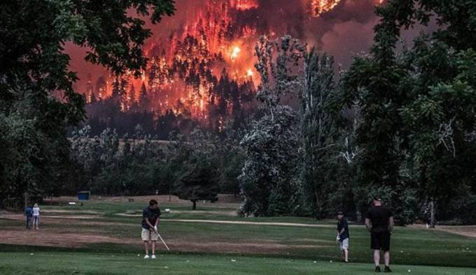 Любители гольфа продолжили игру, несмотря на надвигающуюся огненную стихию, охватившую лес