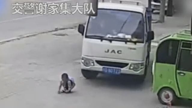 Водитель не заметил маленького ребёнка, играющего перед его грузовиком в Китае (Видео)