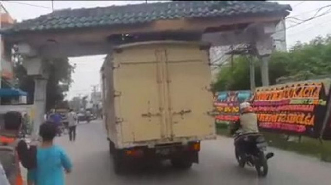 Грузовик с отломленной крышей от ворот, продолжил движение в Индонезии (Видео)