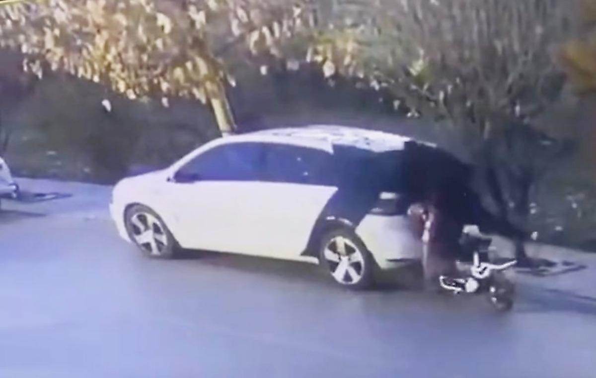 Китайская скутеристка, занятая телефоном, лишила заднего стекла припаркованный автомобиль