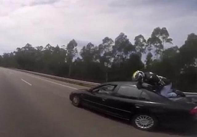 Байкер оказался на крыше автомобиля после столкновения на автотрассе в Португалии. (Видео)