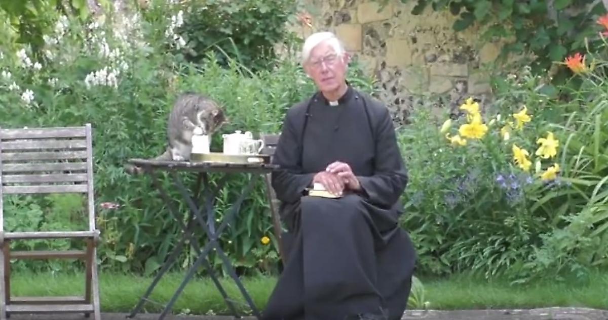 Наглый кот, устроивший трапезу на столе, отвлёк внимание от священника, читающего молитву
