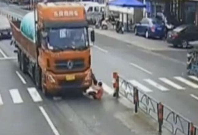 Грузовик сбил женщину, спасающую щенка на пешеходном переходе в Китае (Видео)