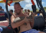 Турист сохранил спокойствие, появившись на пляже с акулой, вцепившейся ему в руку