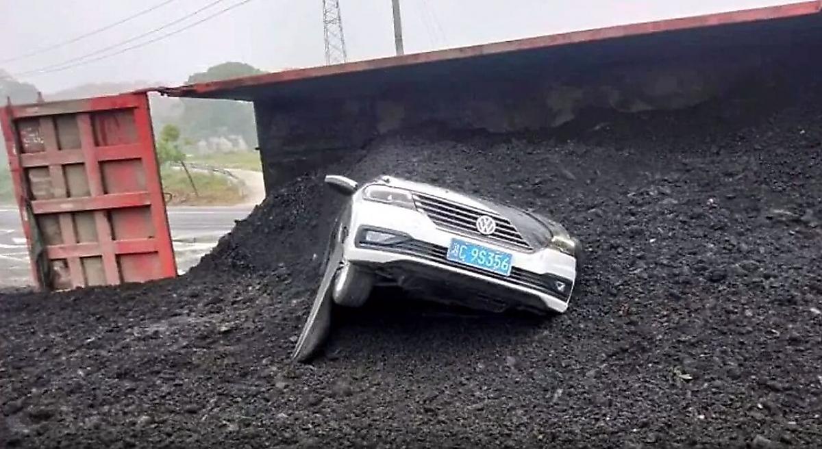 Китайский автомобилист уцелел, угодив под грузовик с углём