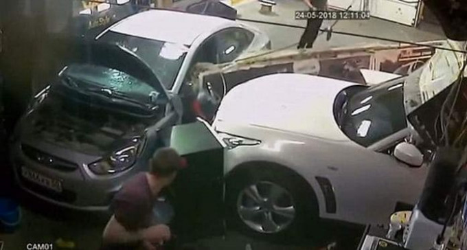 Автомобиль, протаранив стену мастерской, чудом не задел механиков в Москве (Видео)