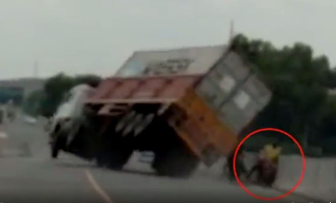 Мотоциклисты чудом не угодили под перевернувшийся грузовик в Индии