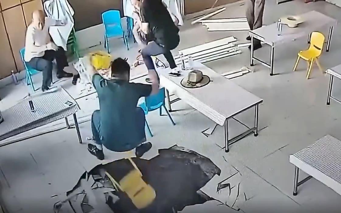 Китаец, сидящий на детском стульчике, чудом не провалился в пролом и попал на видео