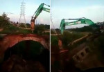 Водитель экскаватора, разрушая мост, похоронил свою спецтехнику под обломками (Видео)