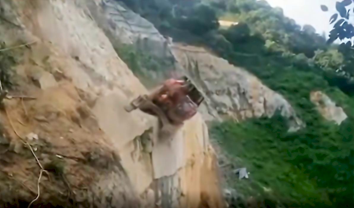 Рабочий обрушил экскаватор со скалы и попал на видео в Китае