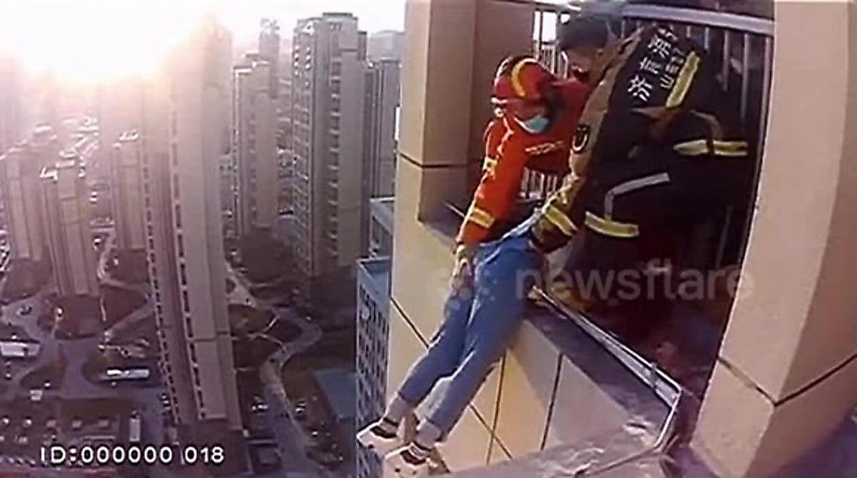 Пожарные насильно спасли китаянку, повисшую на балконе высотного дома