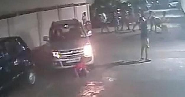 Индийский школьник, завязывающий шнурки, не пострадал, угодив под колёса автомобиля (Видео)
