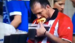 «Сверхпрактичный» футбольный фанат с 8-ю кружками пива, жующий хот-дог, привлёк внимание немецких операторов (Видео)