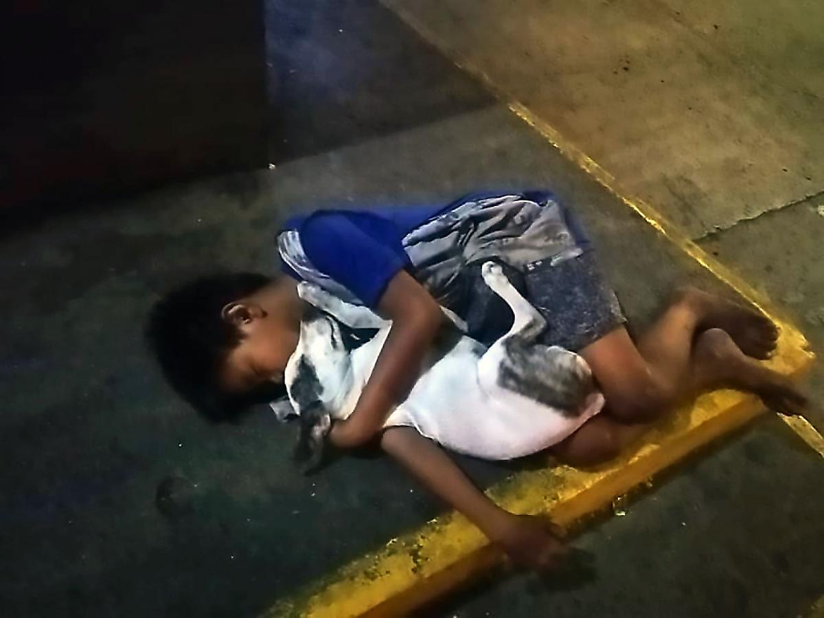 Бездомный ребёнок, заснувший в обнимку с собакой на тротуаре, был запечатлён в Маниле