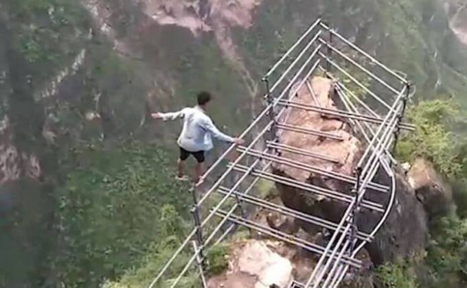Китайский экстремал совершил прогулку без страховки по самой высокой «стремянке» в мире. (Видео)