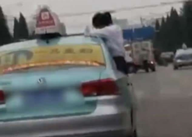 Школьница, делающая уроки, сидя на оконном проёме такси, привлекла внимание полицейских в Китае (Видео)