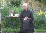 Наглый кот, устроивший трапезу на столе, отвлёк внимание от священника, читающего молитву
