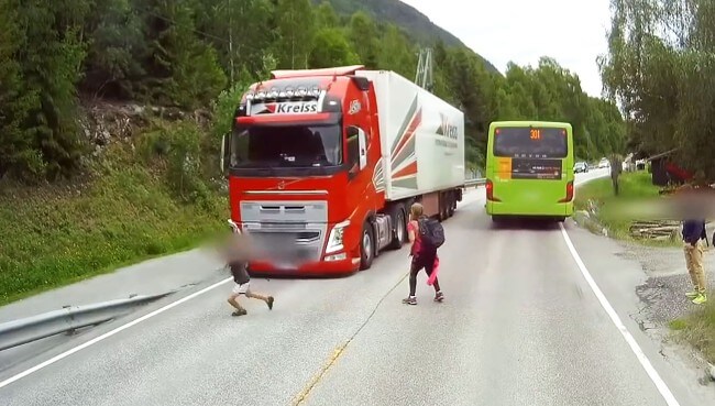 Школьник чудом не оказался под колёсами фуры на автотрассе в Норвегии. (Видео)