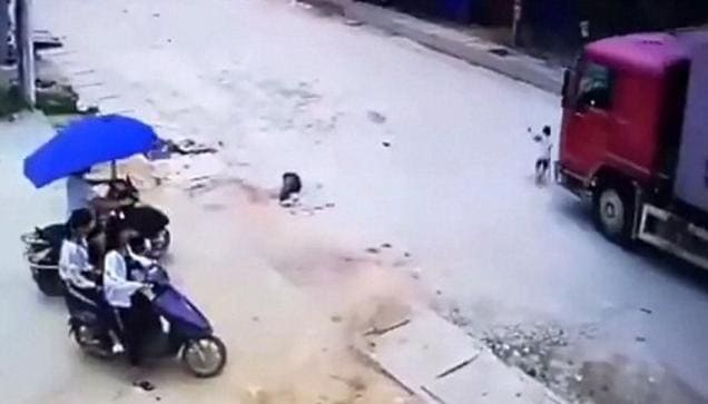 Ребёнок чудом уцелел, оказавшись под колёсами тяжёлого грузовика в Китае. (Видео)
