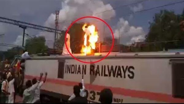 Член партии, забравшийся на крышу поезда, получил мощный разряд током во время забастовки в Индии (Видео)