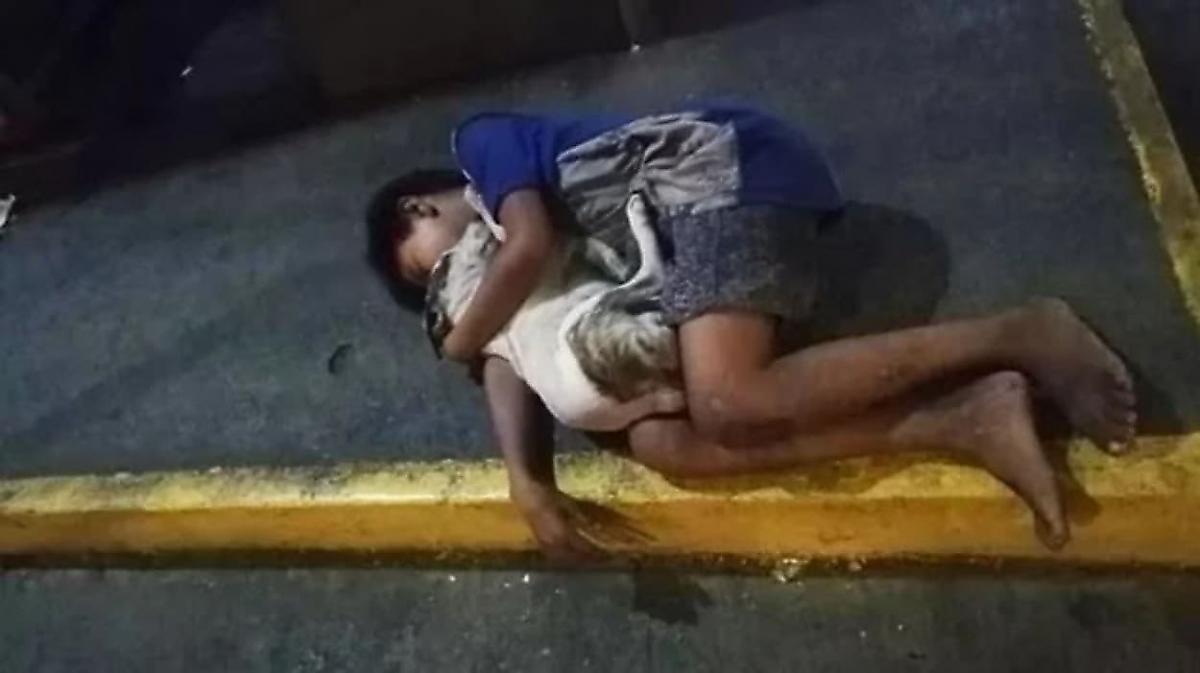 Бездомный ребёнок, заснувший в обнимку с собакой на тротуаре, был запечатлён в Маниле