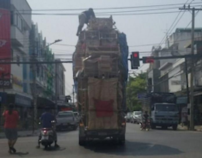 Смелый пассажир страховал груз, забравшись на вершину нагромождения из мебели в кузове грузовика ▶